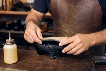 Sapateiro colando a sola de um sapato em Poços de Caldas.